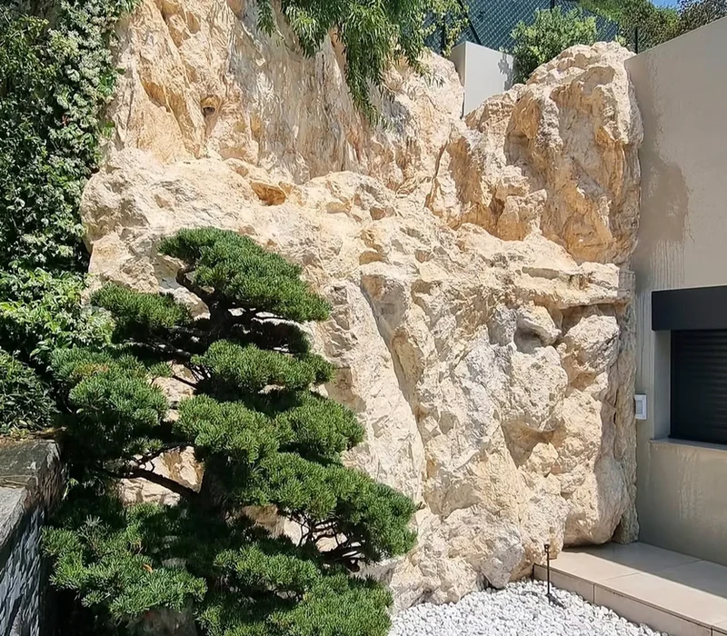 Concrete wall cladding hiding technical equipment behind decorative faux rock – Vallauris