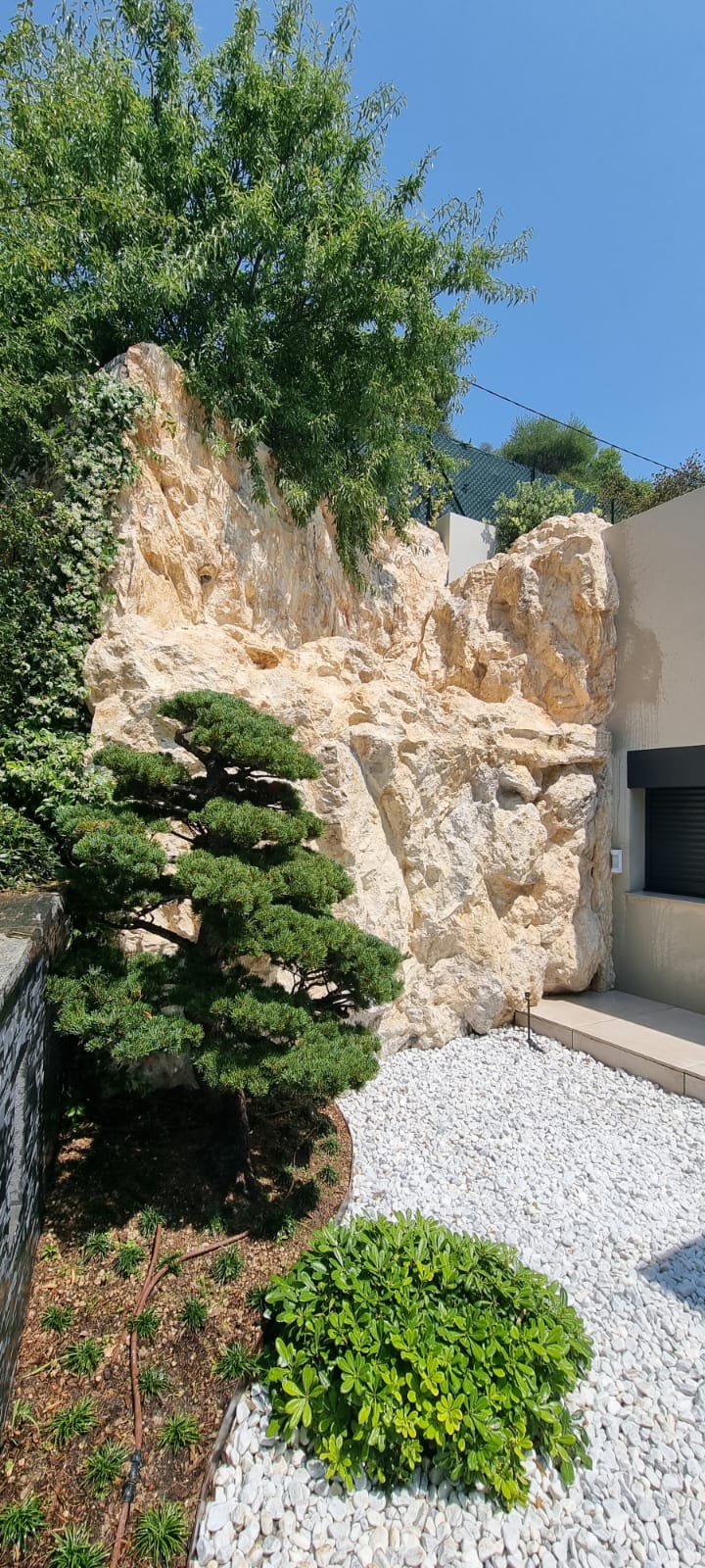Decorado natural de rocas artificiales con bonsái y guijarros