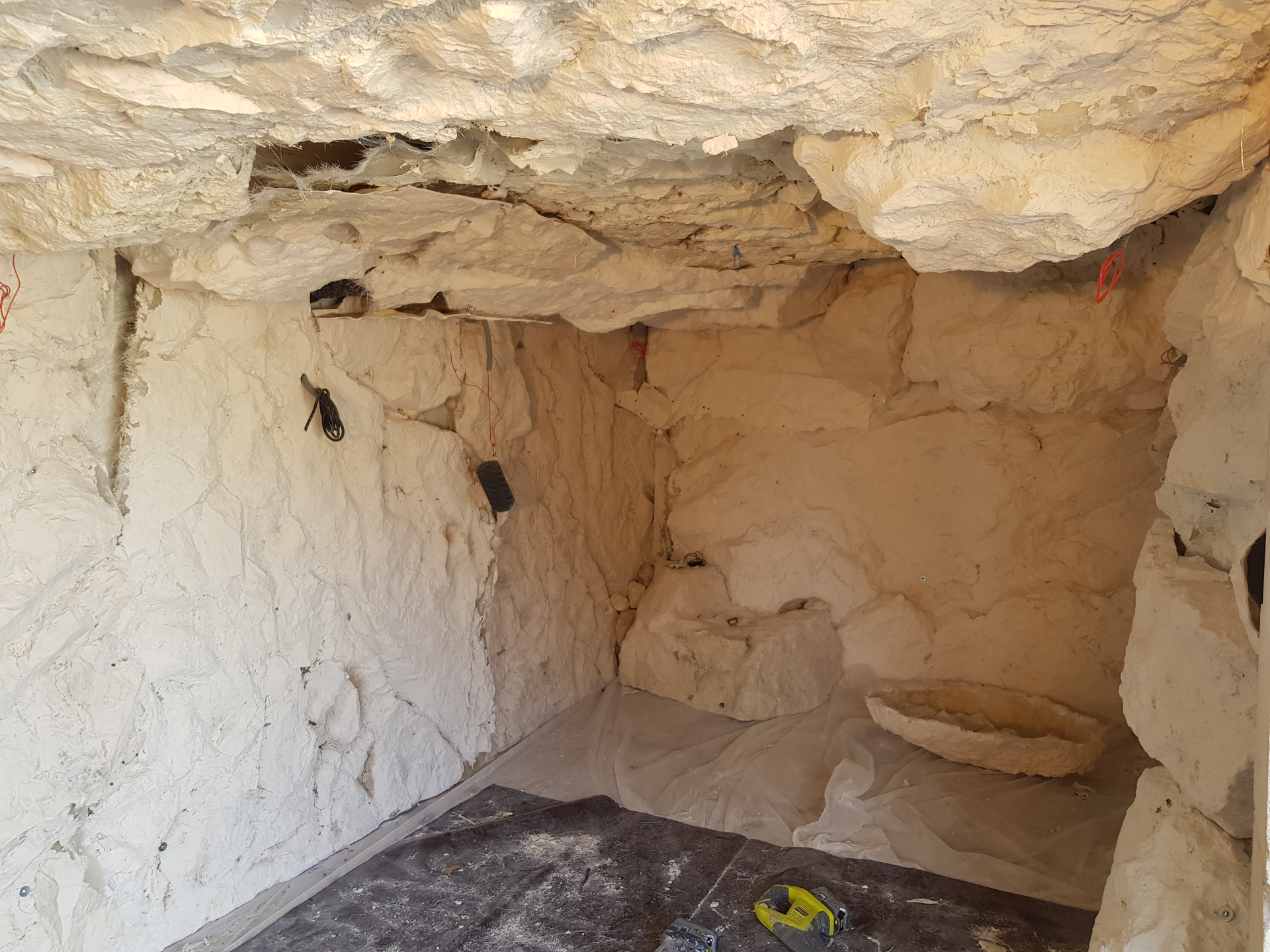 Gruta artificial interior en proceso de realización – revestimiento mural y de techo en roca artificial de poliéster imitando una cavidad rocosa natural