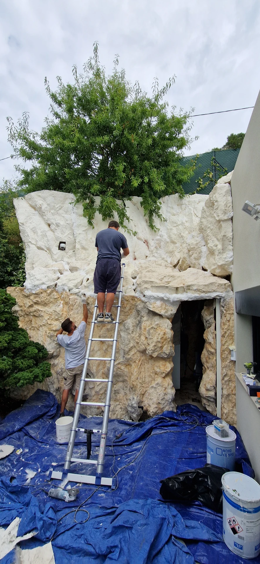 Faux rocks being installed – craftsmen on a ladder