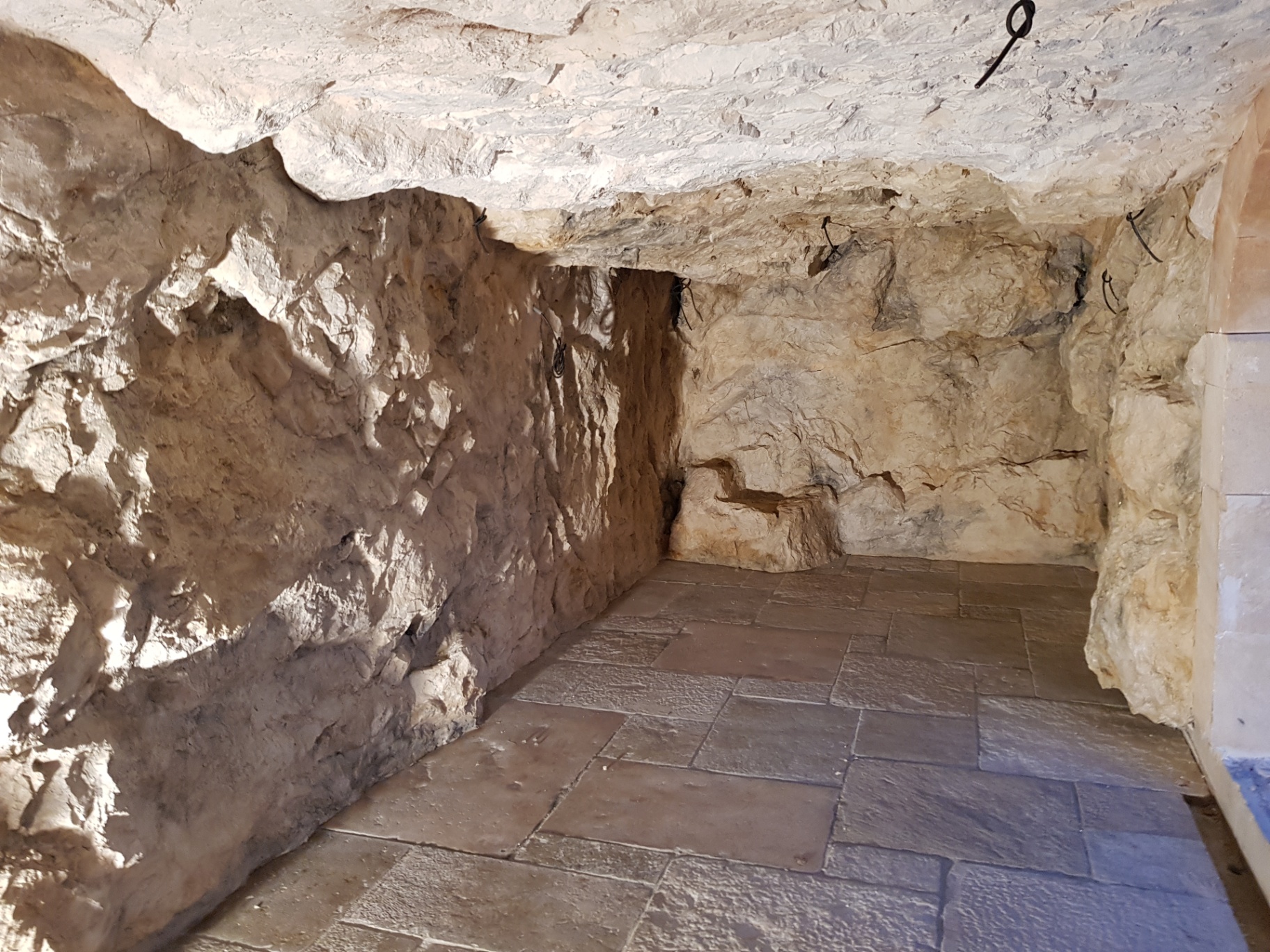 Gruta artificial interior terminada – decorado rocoso inmersivo en roca artificial pátinada a medida con suelo de piedra natural